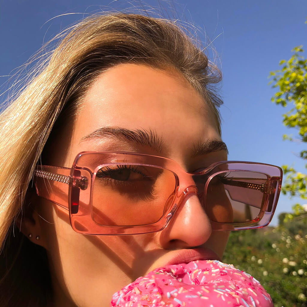 Ameos sunglasses on blonde girl eating a donut